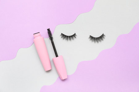 False eyelashes and mascara on color background