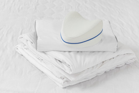 Soft orthopedic pillows and bedding on bed in roomの写真素材