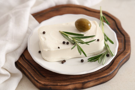 Plate with tasty feta cheese, olive, rosemary and peppercorn on white backgroundの写真素材