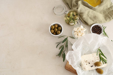 Paper with tasty feta cheese, olives, rosemary and peppercorn on white backgroundの写真素材