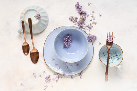 Beautiful table setting with lilac flowers on light grunge background