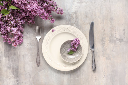 Beautiful table setting with lilac flowers on light grunge backgroundの写真素材
