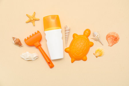 Beautiful composition with sunscreen and beach accessories for children on beige backgroundの写真素材