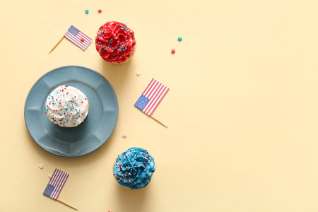 Tasty patriotic cupcakes with USA flags on beige background. American Independence Dayの写真素材