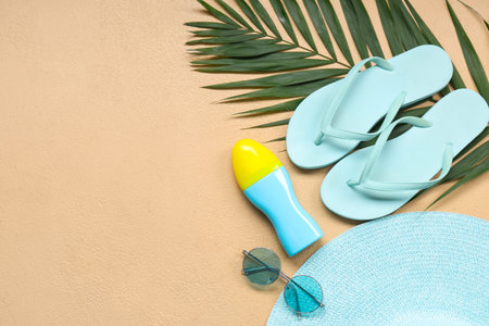 Beautiful composition with beach accessories and sunscreen on beige background