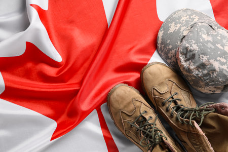 Military boots and cap on Canadian flagの写真素材