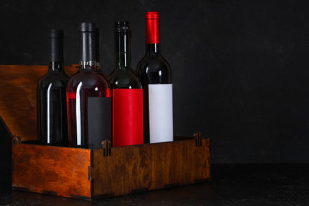 Box with bottles of wine on black grunge backgroundの写真素材