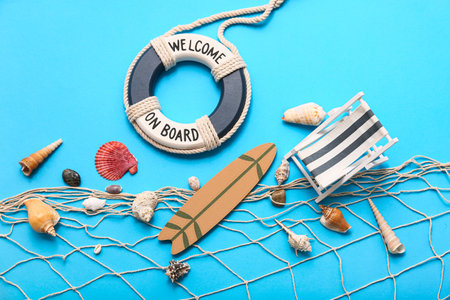 Lifebuoy ring, deckchair, surfboards and seashells on blue background. Summer conceptの写真素材