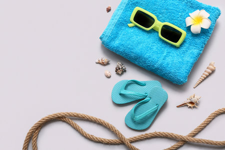 Sunglasses, flip-flops, towel and seashells on gray background. Summer conceptの写真素材