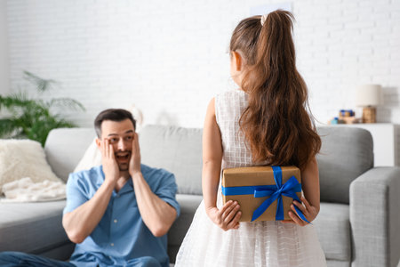 Little daughter making her father surprise in living room. Father's Day celebrationの写真素材