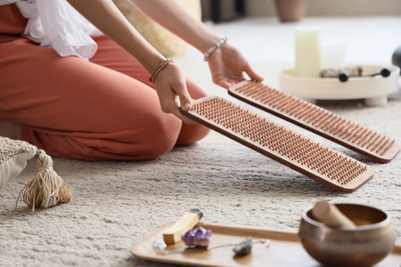 Young woman with Sadhu board on carpet at home, closeupの写真素材