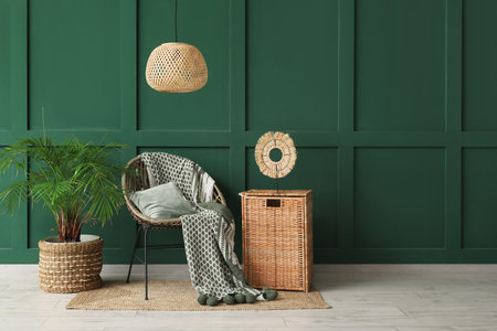 Beautiful interior of living room with armchair, houseplant and wicker boxの写真素材