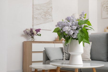 Vase with flowers on table in stylish interior of living roomの写真素材