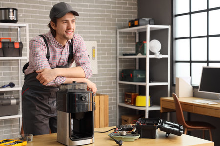 Male repairman with coffee machine in workshopの写真素材