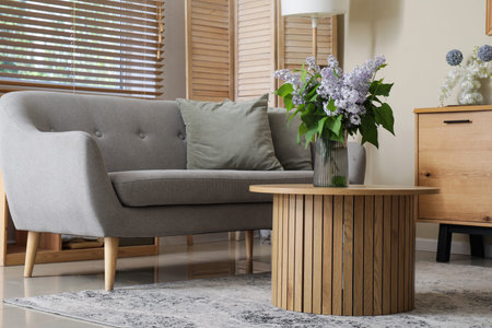 Sofa and round table with flowers in living room