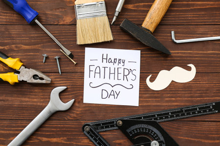 Tools, mustache and greeting card with text HAPPY FATHER'S DAY on wooden backgroundの写真素材