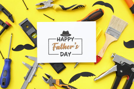 Tools and greeting card with text HAPPY FATHER'S DAY on yellow backgroundの写真素材