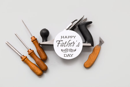 Carpenter's tools and greeting card with text HAPPY FATHER'S DAY on gray backgroundの写真素材