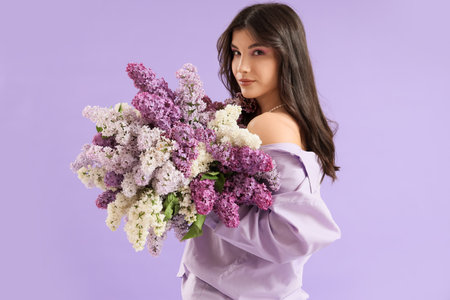 Beautiful young woman with lilac flowers on color backgroundの写真素材