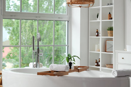 Stylish bathroom with bathtub, shelving unit and window