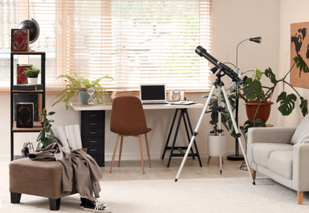 Interior of teenager's room with workplace, plants and telescopeの写真素材