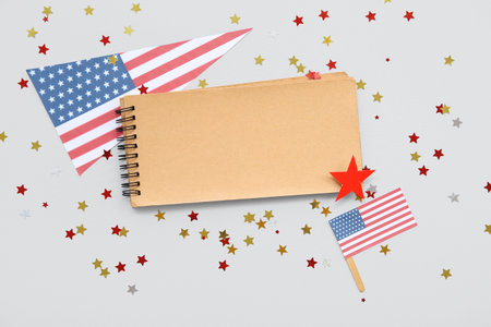 Blank notebook, USA flags and stars on gray background. American Independence Day celebrationの写真素材