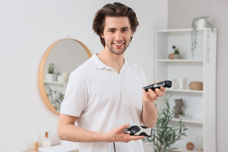 Young bearded man with trimmers in bathroom
