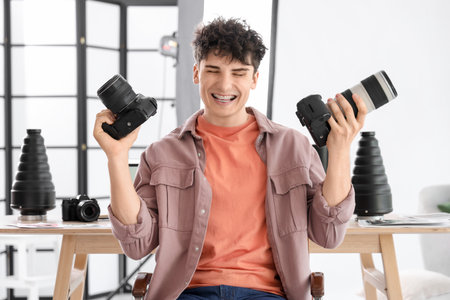 Professional happy male photographer with modern cameras in studioの写真素材