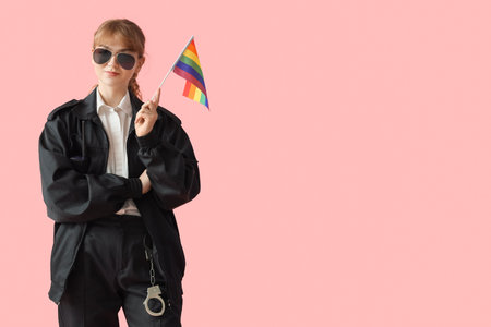 Female police officer with LGBT flag on pink backgroundの写真素材