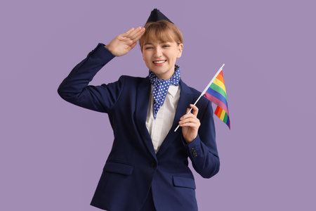 Young stewardess with LGBT flag on lilac backgroundの写真素材