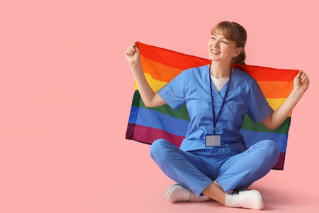 Female doctor with LGBT flag sitting on pink backgroundの写真素材