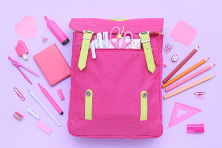 Composition with pink school backpack and different stationery on lilac background