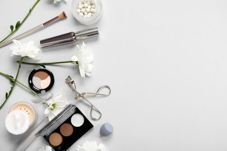 Beautiful composition with flowers and decorative cosmetics on gray backgroundの写真素材