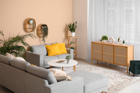 Stylish living room with comfortable sofa, coffee table, chest of drawers and curtains