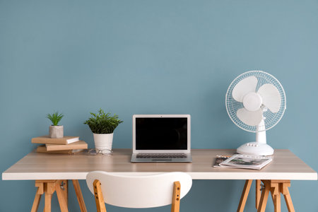 Modern workspace with electric fan and desktop at home officeの写真素材