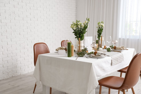Beautiful table setting with eustoma flowers and eucalyptus for wedding celebration in room
