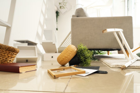 Overturned things on floor in messy living roomの写真素材