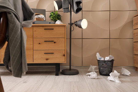 Garbage bin with crumpled paper in messy office
