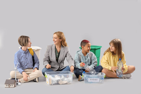Pupils with teacher sorting garbage on light background. Ecology concept