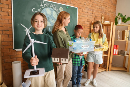 Teenage boy with wind turbine and house model in classroom. Ecology conceptの写真素材