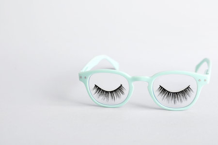Stylish glasses with false eyelashes on gray backgroundの写真素材