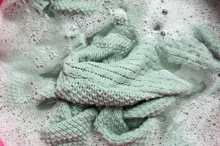 Plastic basin with dirty laundry, foam and water, closeupの写真素材