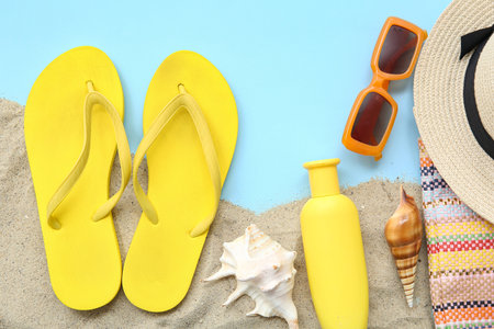 Composition with stylish flip-flops and beach accessories on color background