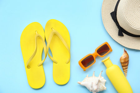 Composition with stylish flip-flops and beach accessories on color background