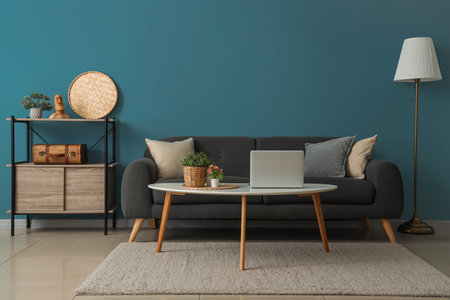 Interior of cozy living room with sofa, coffee table and shelving unit near blue wallの写真素材