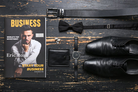 Magazine with male shoes, wallet and accessories on black wooden backgroundの写真素材