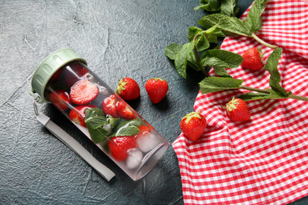Sports bottle of infused water with strawberries and mint on dark backgroundの写真素材