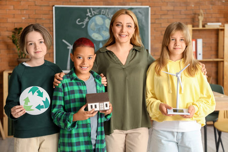 Female teacher with pupils and wind turbine model in classroom. Ecology concept