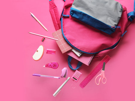 Books and backpack with different school stationery flying on pink background