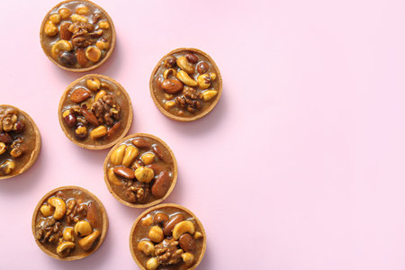 Tasty tarts with nuts and caramel on pink backgroundの写真素材